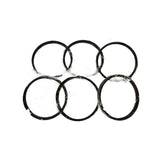 Top-down lay-flat view of six individually wrapped piston rings on white background, showing uniform ring diameter and cross-section. Oil control rings visible with serrated expander profile.