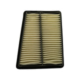 Filter face-up, slight perspective angle. Cream pleated paper media in two columns divided by central grey plastic rib. Black rubber-edged plastic frame visible on all sides. Filter appears unused.
