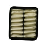 Air filter element removed from box, top face up, showing cream/off-white pleated paper media with black rubber perimeter seal and black plastic centre divider rib; slight yellowing of pleats consistent with shelf age