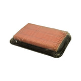 Three-quarter perspective view of filter showing both the top face and one long side; pleated salmon-pink paper element fully visible; black rubber perimeter frame; clear polythene wrap intact and undamaged