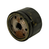 Angled view combining side branding and base plate, showing canister shell, rolled seam, base inlet hole pattern and threaded centre outlet with light orange oxidation.