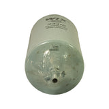 End-on view of the petcock drain hardware: the brass valve outlet sits centred on a slight dome at the closed end of the can