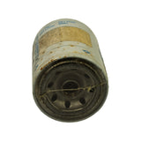 Base end view showing the threaded centre mounting hole surrounded by a ring of oil inlet holes, rubber sealing gasket disturbed with debris/fibre across the face, light surface rust around the lip.