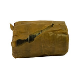 Bearing set in waxed paper wrapper, lateral view. Wrapper is torn along one side exposing edge of cylindrical bearing shells. Faint stamping visible on bearing surface through the gap.