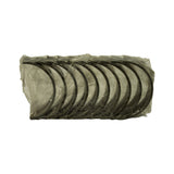 Full-face view of all bearing shells fanned out in original plastic wrap — approximately 10 shells visible edge-on, showing semi-circular profile. Inner bearing surface visible on near shell; appears uninstalled and unmarked.