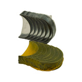 Side-angle view of both stacks showing the semi-circular bearing profile, tang/locating tab visible on the lower stack end, and yellow coating on lower shells in contrast to the silver/dark upper shells.