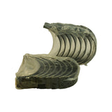 Two stacks of bearing half-shells viewed from above at angle — upper stack is upper halves (with oil hole), lower stack is lower halves. All bearings still in original factory plastic film, some film perforated from handling.