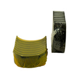 Two individual shells isolated — one upper half (dark grey face, visible locking tab cutout, ridged steel back) and one lower half (yellow protective coating on bearing face, ridged steel back). Shows wall thickness and back texture clearly.