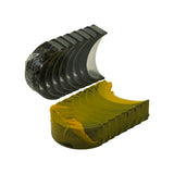 Side-angle view of separated stacks — upper halves showing steel back ridging and tri-metal face, lower half showing broad saddle-shaped profile and yellow protective coating on bearing surface.