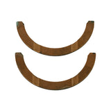Top-down view of both copper-faced half-moon washers, face side up. Warm copper-brown coloration with grooved oil distribution channels across the face. Minor age-related surface discolouration at tips.