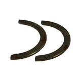 Angled view of both steel-backed washers from a different angle showing consistent curvature and small stamped codes near ends, including what appears to be 'G030'.