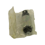 Angled view showing outlet/strainer end of pump still in poly bag, white plastic outlet port visible through wrapping, black strainer housing at rear.