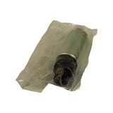 Angled view of pump body in poly bag, strainer end visible at bottom with connector tabs, bare metal cylindrical barrel with minor surface marks through bag.
