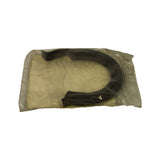 Sealed polybag viewed from reverse angle, showing the other face of the U-shaped rubber seal inside the bag. Bag has mild age-related yellowing and slight wrinkling of plastic.
