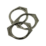 Same three gaskets from rear/underside angle showing aged patina and minor surface oxidation on the back face, octagonal profile clearly visible from this oblique view.
