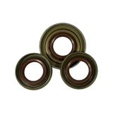 Three shaft oil seals laid face-up in triangular arrangement, front face showing. Brown FKM/Viton elastomer sealing lips with coil spring retainer visible on all three. Steel outer shells with bronze/olive-toned finish. One seal noticeably larger diameter than the other two, which appear close in size.