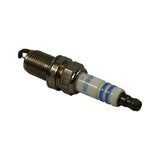 Opposite three-quarter angle showing plug from terminal end toward firing tip. White ceramic insulator, hex, M14 thread, yellow gasket, and curved ground electrode all clearly visible. Suppressor-cap terminal at top.
