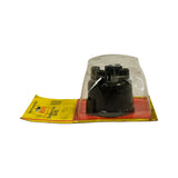 Three-quarter rear view of blister pack. Packaging shows age-related yellowing and curling at card edges. Cap remains undisturbed in dome. All packaging text visible. No damage to the cap itself.