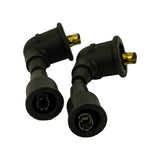 Close-up of two spark plug boots (90-degree style), top view showing open terminal apertures with internal spring-clip contacts visible; gold/brass coloured distributor-end pins exposed above.