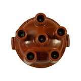 Top-down view looking into the six cylindrical lead towers; M4-type metal contact pins visible inside each tower. Two horizontal lug ears on opposite sides of the rim for distributor mounting. Faint moulded mark appearing to read '73C' and '28/10' visible on cap surface near rim.