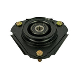 Elevated three-quarter view of strut mount upper side showing the central bearing and surrounding rubber bushing dome, three mounting studs visible at corners, and general triangular form.