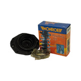 Group shot showing the closed Monroe Mounting Kit box (front face with large Monroe logo and coil-spring artwork), the strut mount, and the bagged bearing arranged together.